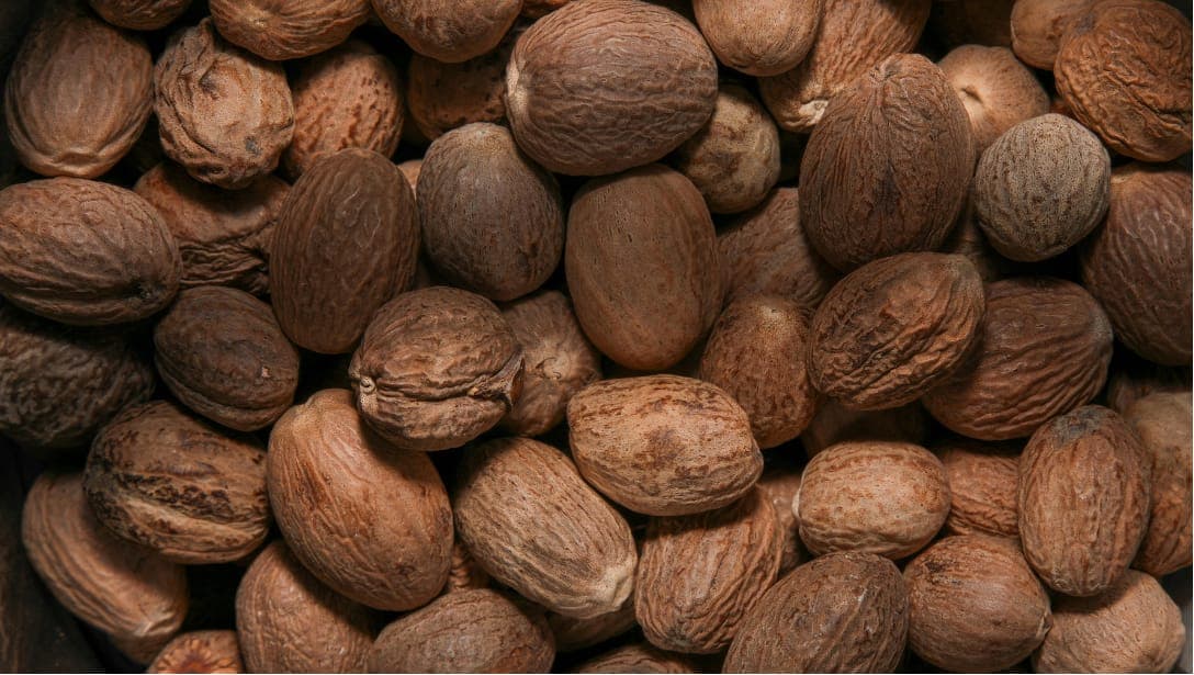 Close-up of a pile of whole nutmeg seeds