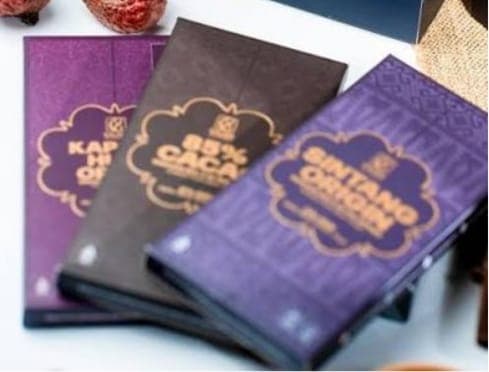 Tiga batang cokelat dalam kemasan, salah satunya berlabel Sintang Origin